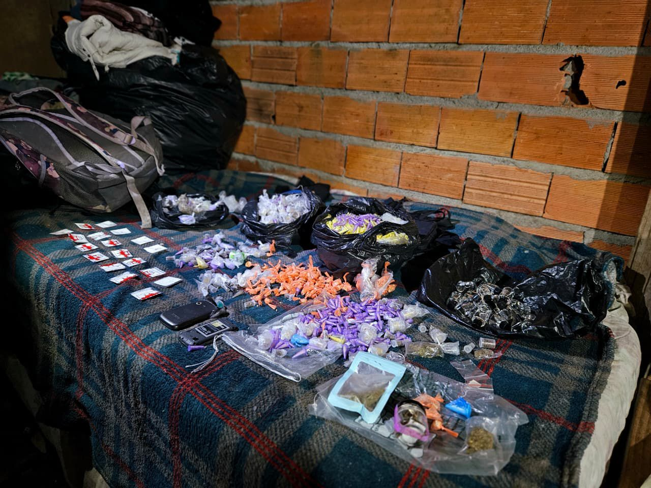 GCM Desarticula "Casa-Bomba" e Apreende Quase 1.500 Drogas em Itaquá Operação Linha Direta, realizada na madrugada, resultou na descoberta de um centro de armazenamento de entorpecentes e na prisão de um homem por receptação. A segurança pública de Itaquaquecetuba deu um passo importante no combate ao tráfico de drogas. Na madrugada desta sexta-feira (14/11), a Guarda Civil Municipal (GCM) desarticulou uma "casa-bomba"—termo usado para designar endereços de armazenamento de grandes quantidades de drogas—durante a realização da Operação Linha Direta. A ação da GCM foi desencadeada após uma denúncia anônima levar os agentes até uma residência no Jardim Miray. Ao inspecionar o local, os agentes encontraram uma quantidade expressiva de entorpecentes: um total de 1.470 porções de drogas, incluindo os perigosos "drogas k", além de crack, cocaína e lança-perfume. Para dar mais detalhes sobre o esquema criminoso, também foram apreendidas anotações que detalham a contabilidade do tráfico. Reforço na Segurança e Prisão por Receptação A Operação Linha Direta, que contou com a mobilização estratégica de 20 viaturas para coibir roubos e o tráfico, não se limitou ao Jardim Miray. Os agentes da GCM percorreram mais de 50 bairros do município, reforçando o patrulhamento. Durante estas rondas, houve outro resultado positivo: a recuperação de uma motocicleta roubada no bairro Parque Recanto Mônica. Na mesma ocorrência, um homem foi detido e será responsabilizado pelo crime de receptação. A GCM reforça o papel da denúncia anônima como ferramenta crucial para a desarticulação de crimes na cidade. Crédito da Imagem: Divulgação